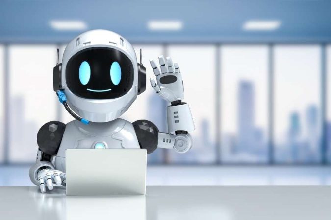Un petit robot blanc souriant travaille sur un ordinateur portable et fait un signe de la main.